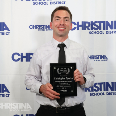 Photo of Christopher Sparks Teacher of the Year Maclary ES with award